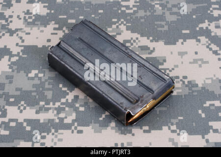 US ARMY M16 Rifle 20rd Magazine Vietnam war period with ammo on camouflaged uniform background Stock Photo