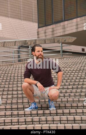 Outdoor photo shoot with a man, with beard and long hair. Stock Photo