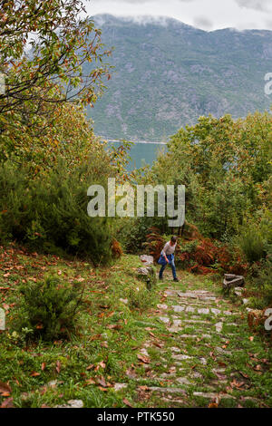 Female hiker on the steep path up to Gornji Stoliv from the coast road round Boka Kotorska, Montenegro.  MODEL RELEASED Stock Photo