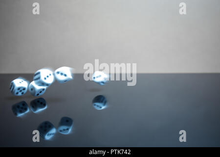 Thrown dice blurred by movement, reflective surface Stock Photo