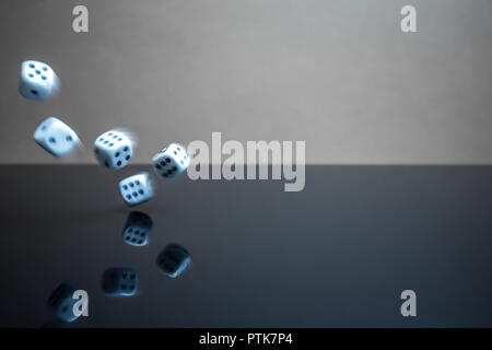 Thrown dice blurred by movement, reflective surface Stock Photo