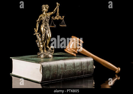 Statue of Justice on the book and wooden gavel on the black background Stock Photo
