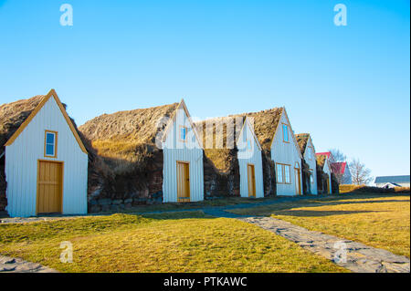 Traditional turf houses of Glaumbauer ethnographic Farm Museum, Skagafjordur, Iceland. Colourful row of picturesque cottages against clear blue sky Stock Photo