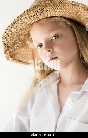 portrait of beautiful little kid in wicker hat looking at camera on white Stock Photo