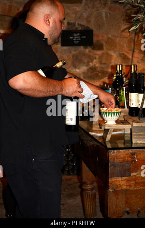 A tourist prepares to purchase bottles of wine in the tasting room at Castello di Amorosa winery, housed in a reproduction 13-century medieval Italian Stock Photo