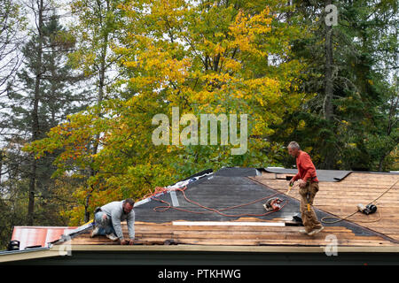 Two men working on repairing a roof. Stock Photo