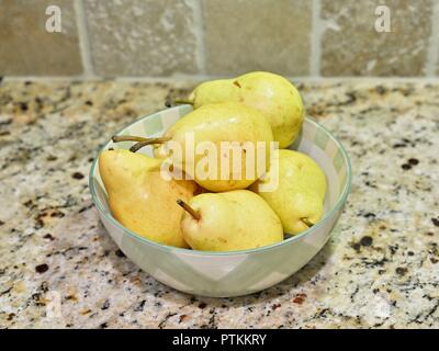 Ripe Williams' bon chrétien pear fruit, commonly called the Williams pear or the Bartlett pear or pears in a bowl on a kitchen counter top. Stock Photo