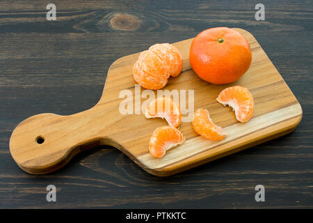 Tangerine segments on a wood cutting board Stock Photo