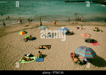 Holidaymakers sunbathe on the beach, Torviscas, Playa El Duque, Costa Adeje, Tenerife, Canary Islands, Spain Stock Photo