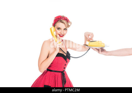 young pin up woman dialing phone number of retro telephone on serving tray in male hand isolated on white Stock Photo