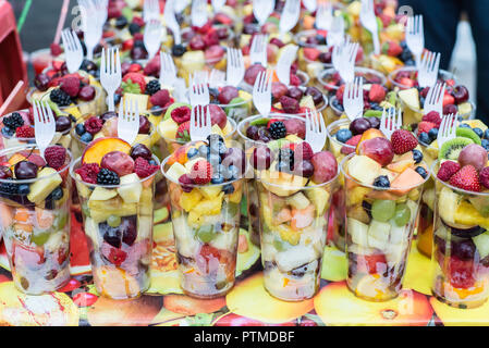 Take away salad of healthy sliced organic berries and fruits at a market stall in Brik Lane, London. Stock Photo