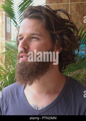 Bearded man looking away. Good looking, young man with berad smiling. Stock Photo