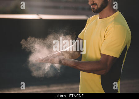 cropped image of sportsman clapping hands with talc powder on roof Stock Photo