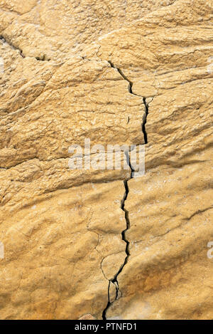 Natural brown rock texture with a long fault, eroded by the water Stock Photo