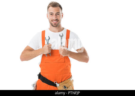 smiling handsome auto mechanic in orange uniform showing wrenches isolated on white Stock Photo