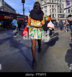 Colourfully-dressed young woman in Oxford Circus, London, England, UK. Stock Photo