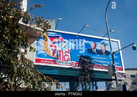 A large billboard showing ex Khmer Rouge members PM Hun Sen (r) & national assembly president Heng Samrin, tower over a street in Phnom Penh,Cambodia Stock Photo