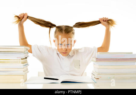 Overwhelmed little girl with a negative attitude towards studies and school after studying too much and having too many homework in children education Stock Photo