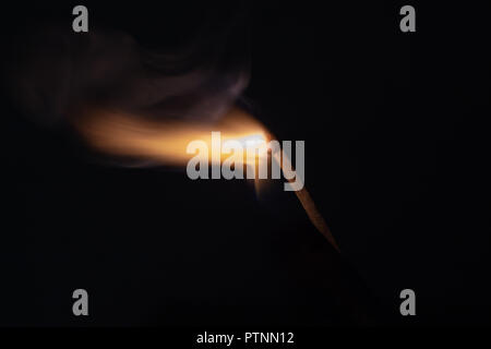 Match with strongly flaring flame on a black background closeup Stock Photo