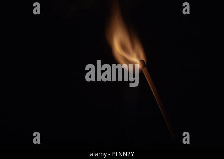 Match with strongly flaring flame on a black background closeup Stock Photo