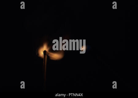 Match with strongly flaring flame on a black background closeup Stock Photo