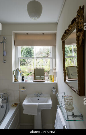 Majolica heron jug on windowsill  Edwardian style bathroom with view to garden Stock Photo