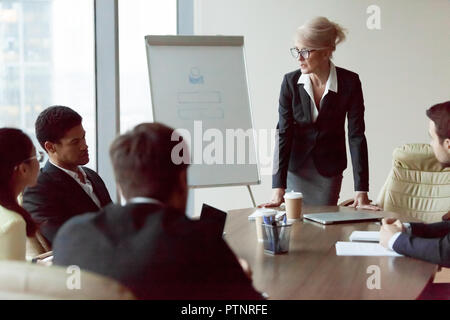 Serious businesswoman talk during company briefing in office Stock Photo