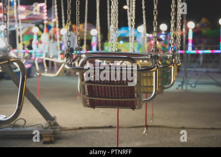 Carousel in the illuminated amusement park in the evening. Stock Photo