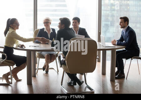 Employees shaking hands at business negotiation in office Stock Photo