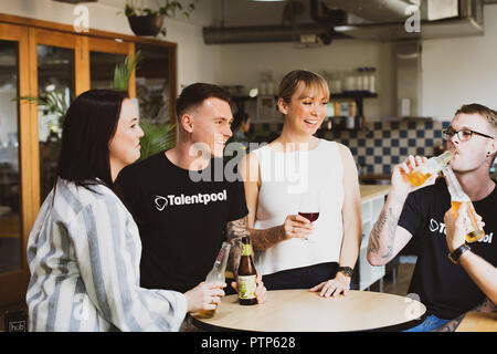 Businesspeople relax after a hard day's work with a few drinks in a co-working space Stock Photo
