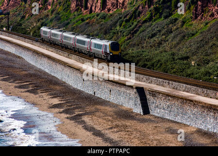 DAWLISH, DEVON, UK - 3OCT2018: Arriva Cross Country Class 220 High Speed Train travelling north along the sea wall at Dawlish. The Langstone Rock can  Stock Photo