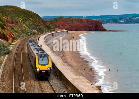 DAWLISH, DEVON, UK - 04OCT2018: Arriva Crosscountry Class  220 Voyager train  travelling south along the sea wall at Dawlish. Langstone Rock is in the Stock Photo