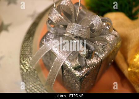 Square Shaped Silver Glitter Gift Box Ornament on the Silver Plate for Seasonal Decoration Stock Photo