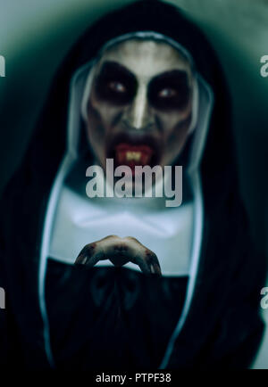 closeup of a frightening evil nun, with bloody teeth, wearing a typical black and white habit Stock Photo