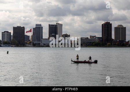 Detroit, Michigan - Two men fishing from a small boat on the Detroit River. Windsor, Ontario, Canada is on the far side. Stock Photo
