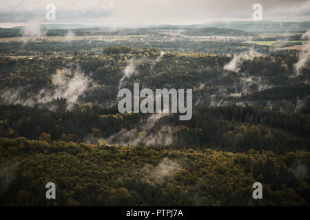 Deadpan dark misty rainy morning landscape with the sand rocky montains in Czech Saxon Switzerland in autumn colors. Stock Photo