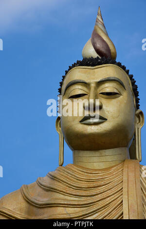 Giant golden Buddha, part of the colourful temple of Wewurukannala Vihara, 2 miles north of Dikwella, Sri Lanka, Asia. Stock Photo