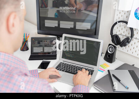 Programmer working on the code. IT specialist codes the responsive website Stock Photo