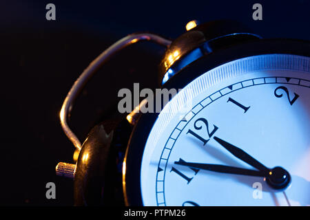 Five minutes to midnight. Changing the clocks, time adjustment, daylight savings or new year concept on retro analog clock. Stock Photo