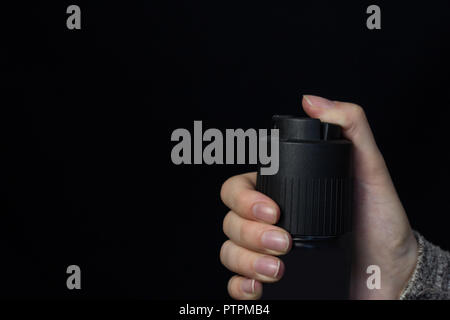 Female hand with a gas spray on a black background, close-up Stock Photo