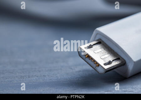 Closeup of micro usb smart phone power cable on a wooden background. Stock Photo