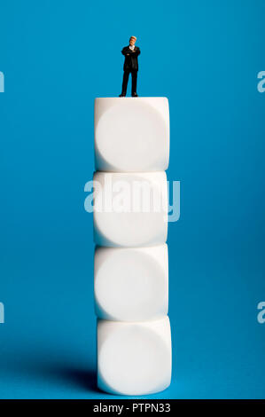 miniature figurine of a businessman standing on top of dice, success in business concept Stock Photo