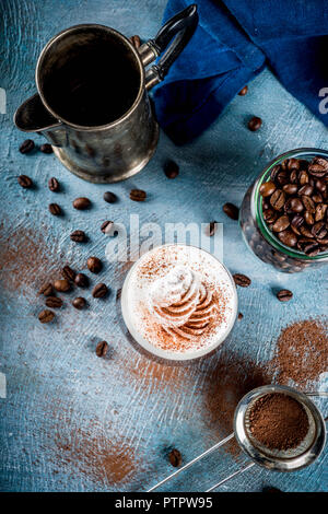 Autumn espresso drink ideas, Irish coffee cocktail with whipped cream and cocoa, blue concrete background copy space