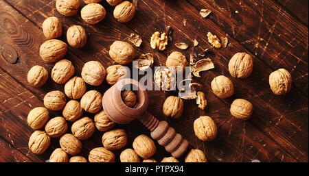 Nutcracker and nuts lying on table Stock Photo