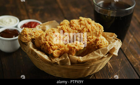 Fried chicken wings near sauces and drink Stock Photo