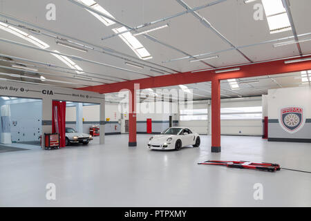 Brand new auto body shop for luxury cars with two cars parked inside