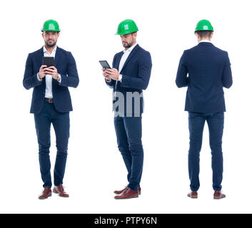 Young engineer in helmet checking the processes in tablet, front, side, rear view, isolated on white Stock Photo