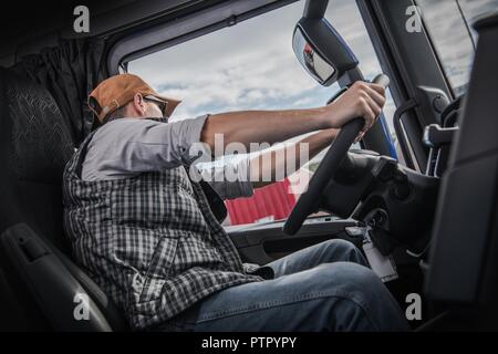 Relaxed Caucasian Truck Driver Seating on the Ground and Support His Back  on the Semi Truck Wheel Stock Photo - Alamy