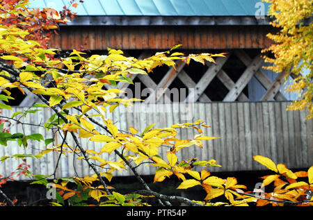 Beautiful Fall foliage surrounds the historic Silk Road covered bridge in Bennington, Vermont, USA. Stock Photo