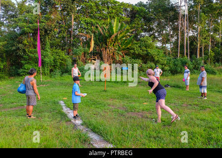 Ko Mak, Thailand - December 14, 2017. Group of friends playing frisbee golf (disc golf) Stock Photo